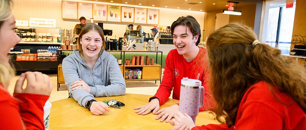 Four students sitting at a table at the on-campus Starbucks location.